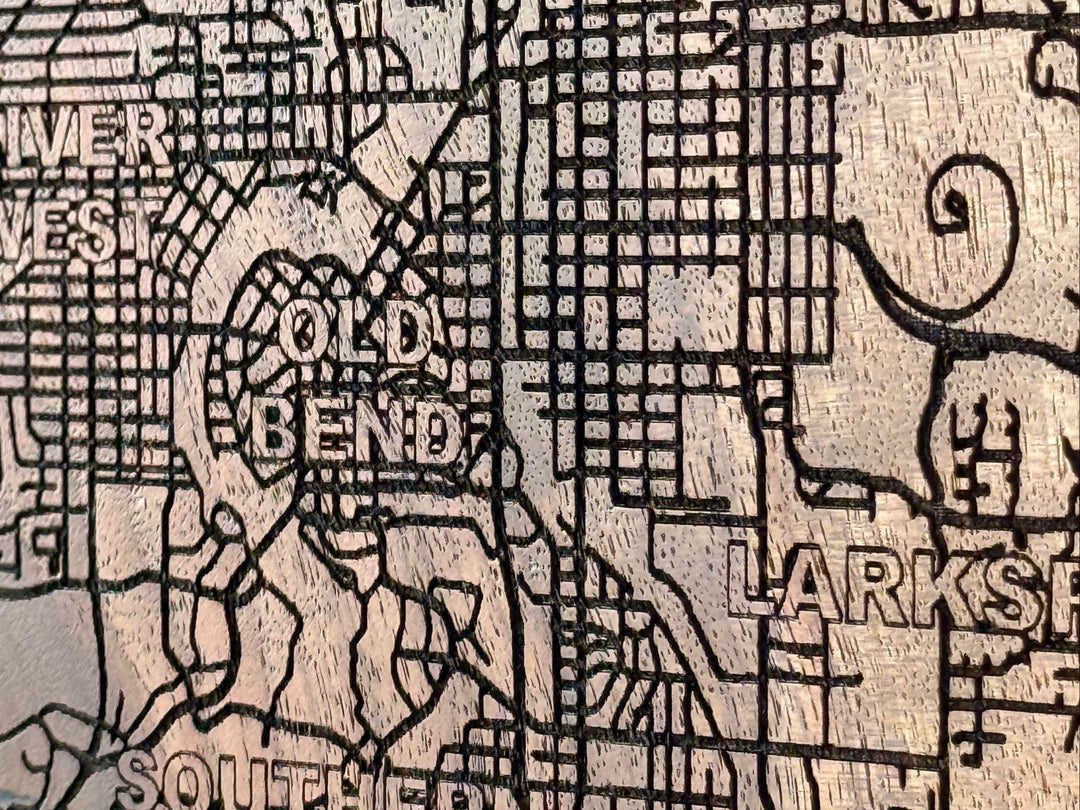 Wooden engraved map of a town with street names and landmarks.