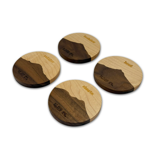 Set of four wooden coasters with a natural wood and dark wood design on a white background.